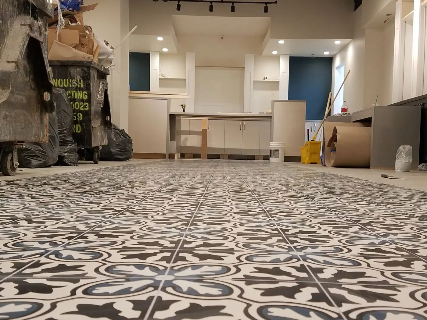 Hand painted patterned tile recessed into polished concrete in the Brooklyn pharmacy