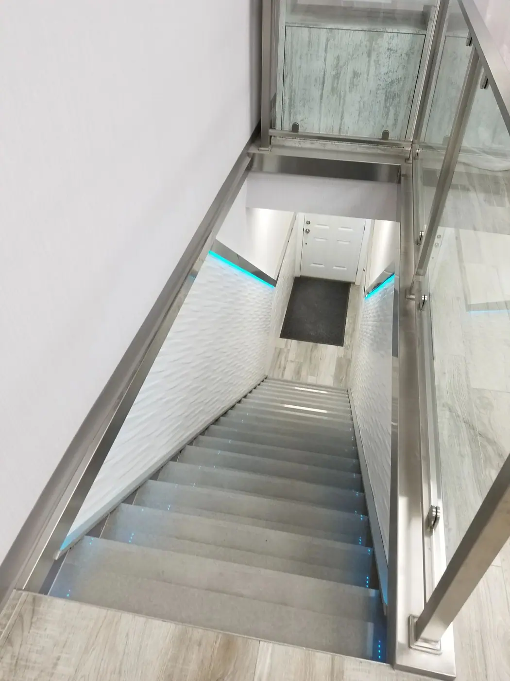 Finished staircase with a glass balustrade and stone treads