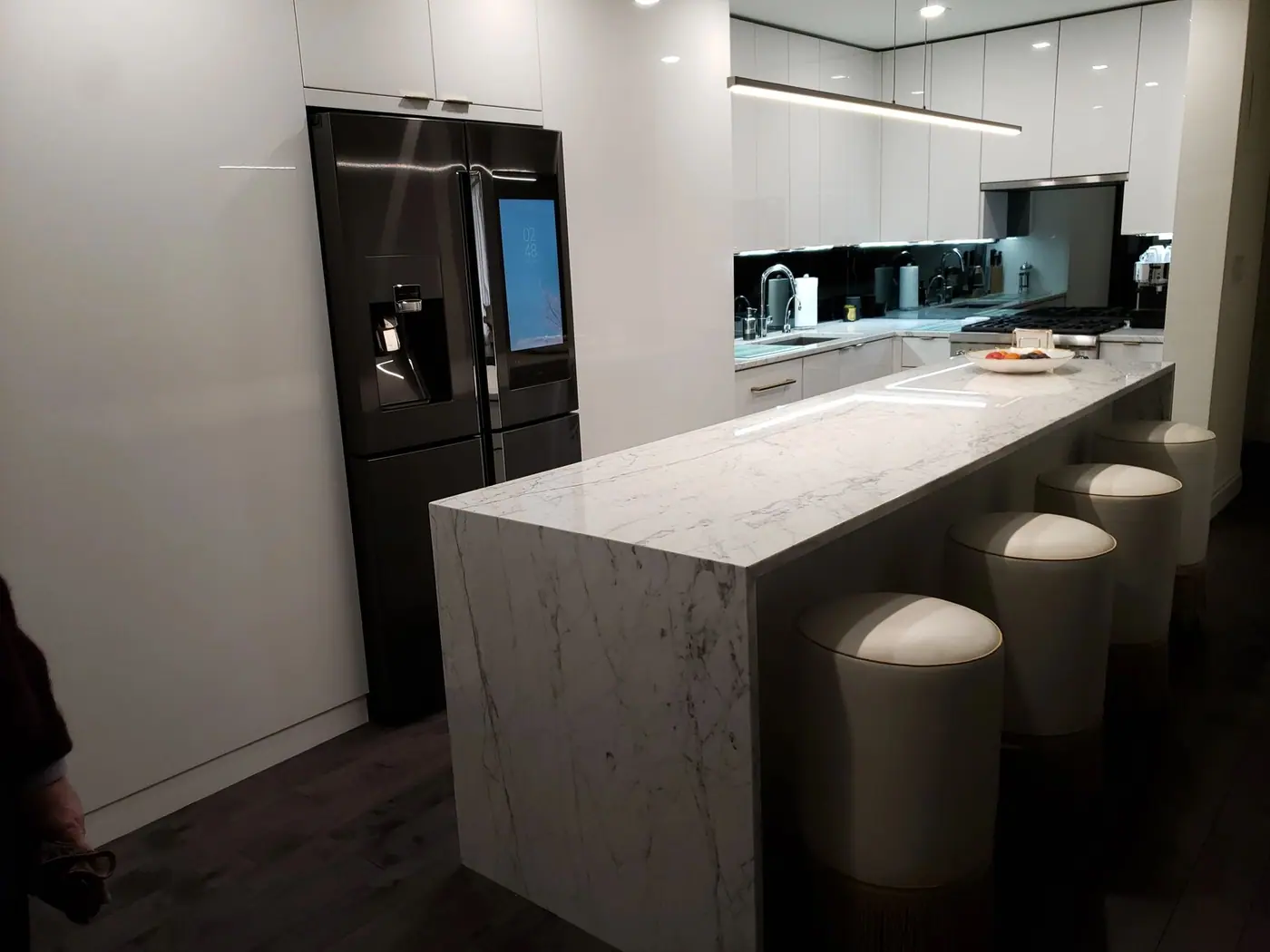 Kitchen with a stone waterfall counter and integrated appliances built by Advanced Builders Group