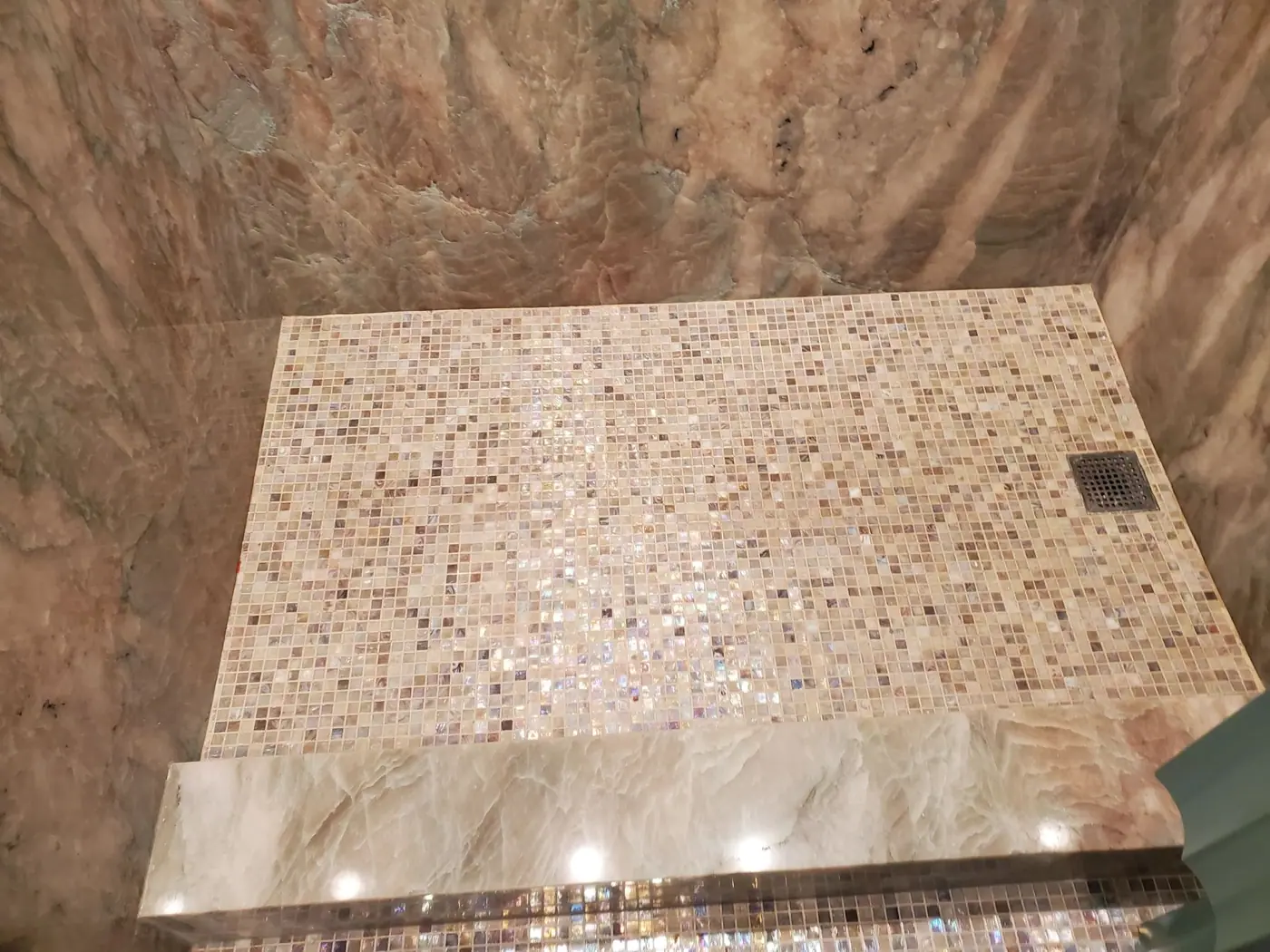 Marble clad wet room with a mosaic tile shower floor