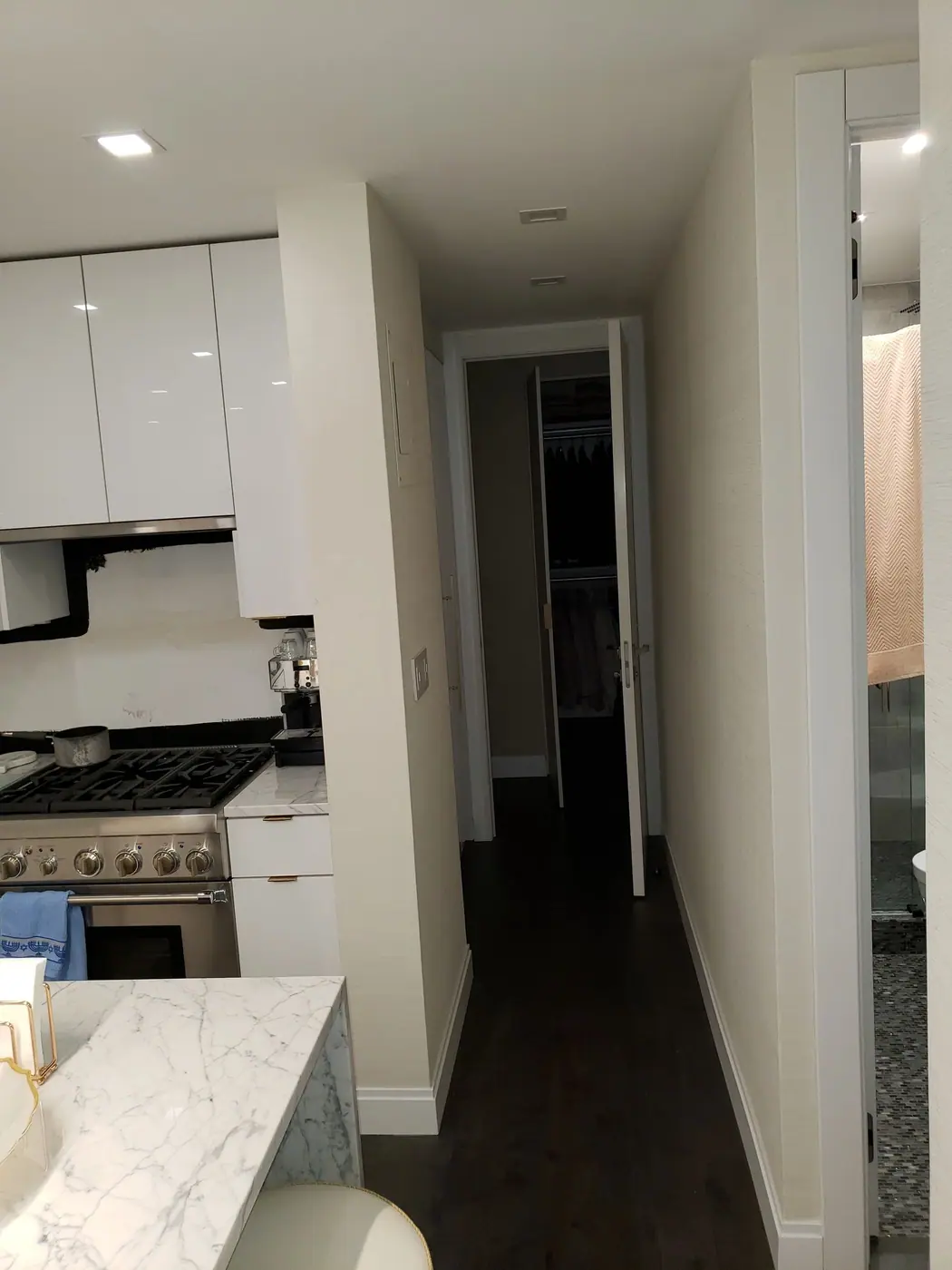 Finished galley kitchen with a marble waterfall counter in the Sutton Place condo renovation