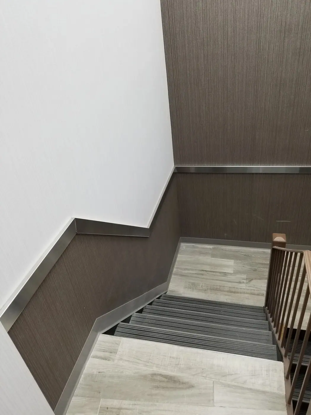 Finished stair landing with timber panelling and a tiled floor